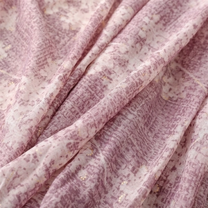 Macro detail of lavender silk shawl featuring gold metallic accents and geometric patterns