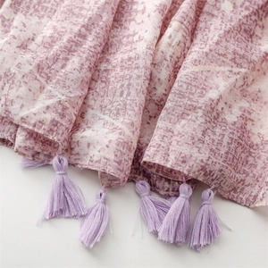 Detail of light purple shawl featuring ethnic print and matching silk tassel fringe edges