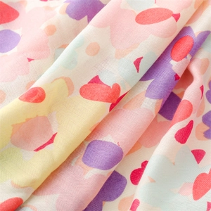 Close-up of soft linen-touch scarf showing colorful floral print and herringbone texture