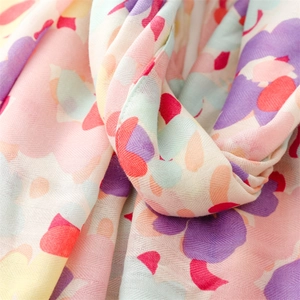 Detailed macro view of linen-feel scarf fabric showing colorful floral print and herringbone weave