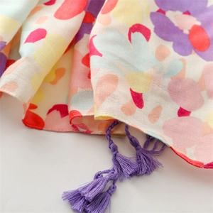 Detail of colorful floral print shawl with purple tassels and herringbone weave texture