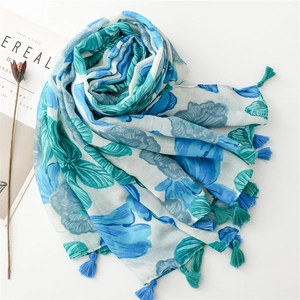 Detail of floral print scarf with soft tassels and artistic linen-touch fabric texture