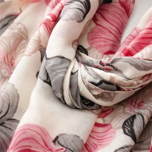Close-up of soft linen-feel scarf fabric featuring pink and grey floral patterns