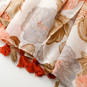 Detailed close-up of floral print scarf with soft fringe edges and linen texture