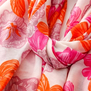 Close-up of bright pink floral print on lightweight linen scarf with woven texture
