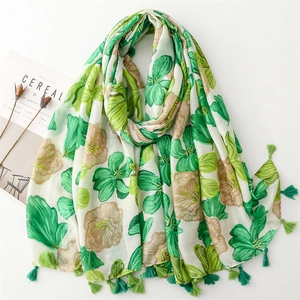 Macro view of floral print scarf with green tassel details and soft linen-feel fabric