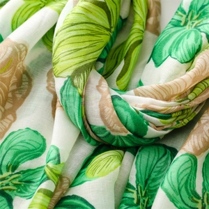 Detailed macro view of linen texture featuring emerald green leaf and tan flower prints