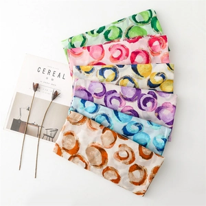 Detail of colorful cotton linen scarves with abstract circle prints and frayed edges