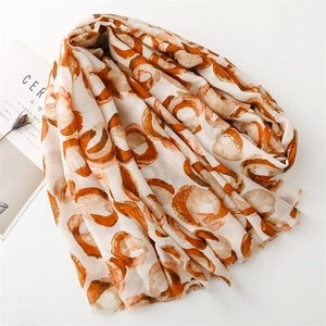 Detail of soft cotton linen shawl with gold foil donut pattern and frayed edges