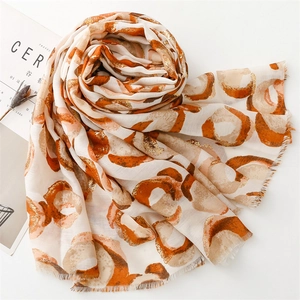 Detail of cotton linen scarf with gold foil donut print and soft frayed edges
