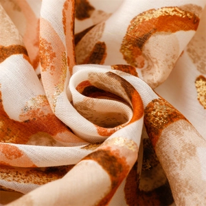 Macro view of cotton-linen feel scarf featuring gold foil prints and warm leopard pattern