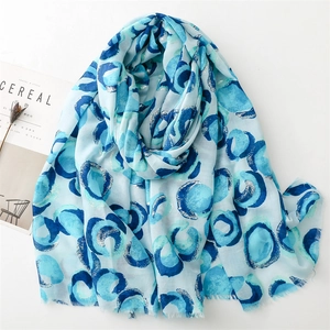 Detail of blue circular pattern on cotton-linen scarf with silver foil stamping accents