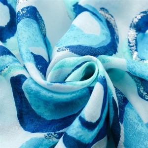 Detail view of cotton linen feel scarf with gold foil dots and fringe edges
