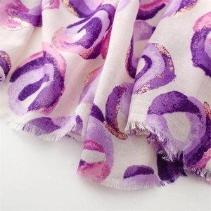 Detail of purple cotton linen scarf with gold foil donut patterns and frayed edges