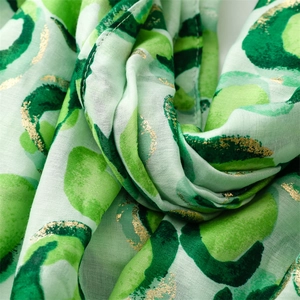 Close-up of leopard print scarf with gold foil accents and soft cotton linen texture