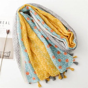 Detail eines Patchwork-Schals mit Blumenmuster, Geometrie und feinen Quasten am Rand