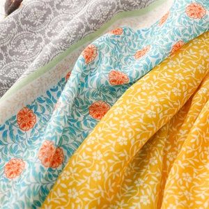 Detailaufnahme von Schals mit Leinenhaptik, floralem Muster und weichen Quastenkanten