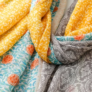 Detail eines Leinen-Schals mit Vintage-Rosenmustern und feiner Fransenstruktur am Rand