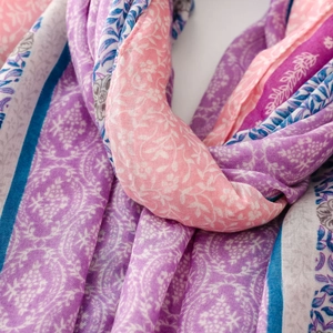 Detail eines weichen Schals mit rosa und königsblauen Paisleymustern und Fransen