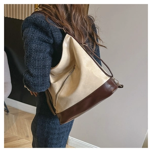 Detail of the high-capacity tote bag with two-tone faux leather and metal zipper