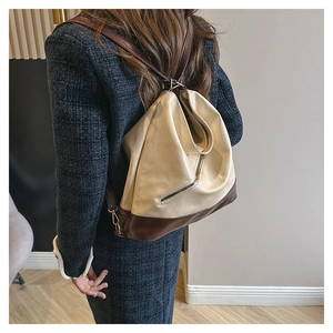 Detail view of the back zipper pocket and adjustable straps on the cream tote bag