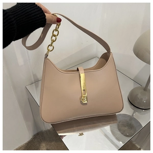 Detail of the nude beige leather handbag featuring a signature gold metal clasp and chain