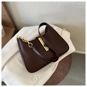 Detail view of smooth brown PU leather shoulder bag with gold metal buckle and chain strap