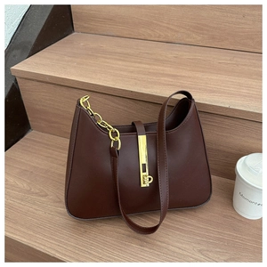 Close-up of retro dark brown underarm bag featuring a gold chain and hardware lock