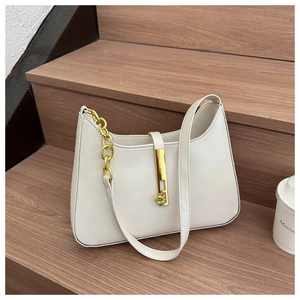 Detail view of cream leather shoulder bag with gold metal buckle and chunky chain link