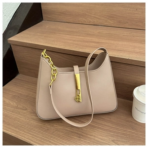 Detailed shot of beige leather crossbody bag with gold hardware buckle and chain accent