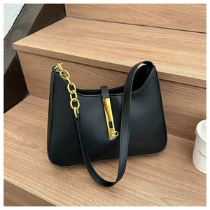 Detail of vintage black faux leather shoulder bag with gold chain and metal buckle