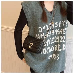 Vue latérale du sac bandoulière noir matelassé en V avec chaîne dorée sur un mannequin