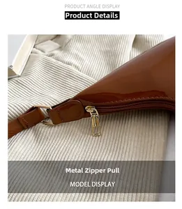 Detailed close-up of premium golden metal zipper pull on brown patent leather handbag