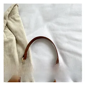 Detail of glossy patent leather shoulder bag handle with elegant gold metal buckle