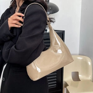 Chic beige patent leather hobo bag with a glossy finish and minimalist shoulder strap