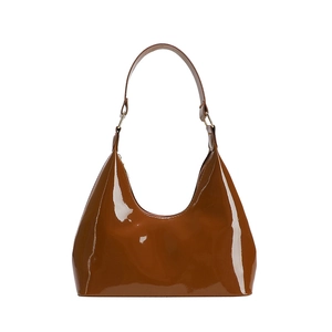 Glossy caramel brown patent leather hobo underarm bag with a minimalist half-moon design