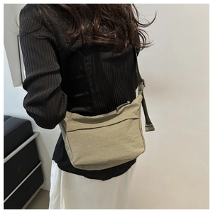 Close-up of olive green crossbody bag showing nylon material and wide adjustable strap