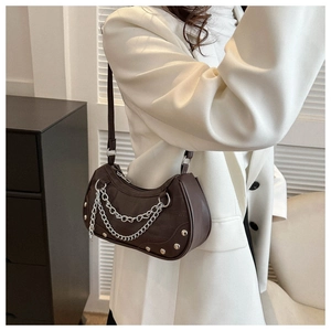 Detail of dark brown crescent bag with silver rivet chains and croc texture