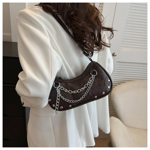 Model wearing dark coffee crocodile pattern crescent bag with silver chain and rivets