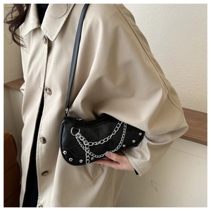 Detail of black crescent shoulder bag with crocodile texture and silver chain strap