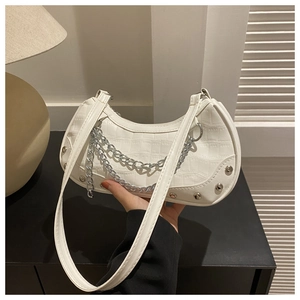 Detail of white crocodile texture hobo bag with silver chains and rivet embellishments