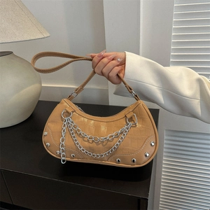 Crocodile texture shoulder bag with silver chains and rivets shown in hand