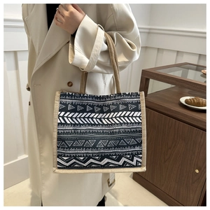 Detail of bohemian burlap tote bag featuring black and white geometric tribal patterns