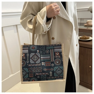 Close-up of patterned linen tote bag with ethnic geometric embroidery and jute handles