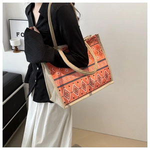 Detail of bohemian orange tote bag with geometric patterns and woven handles