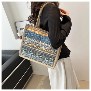 Detail of bohemian geometric tote bag with thick woven handles and ethnic fabric texture