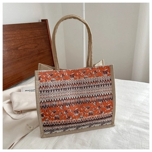 Detail of bohemian linen tote bag featuring retro floral and geometric orange patterns