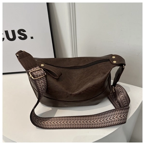 Detail of retro dark brown bag with woven geometric strap and gold-tone hardware accents