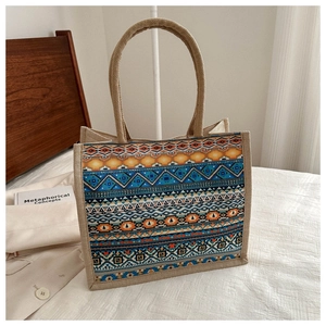 Detail of bohemian linen tote bag featuring geometric patterns and woven handles