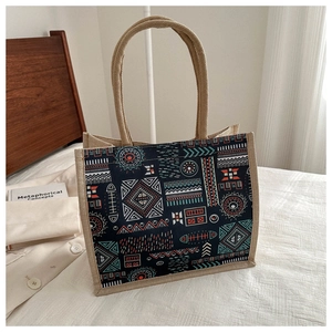 Detail of bohemian tote bag with geometric patterns and sturdy jute handles on white linen